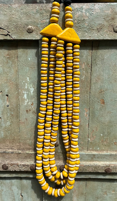 Collier artisanal jaune et blanc décoration murale