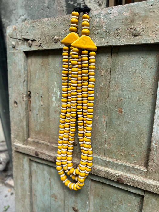 Collier artisanal jaune et blanc décoration murale